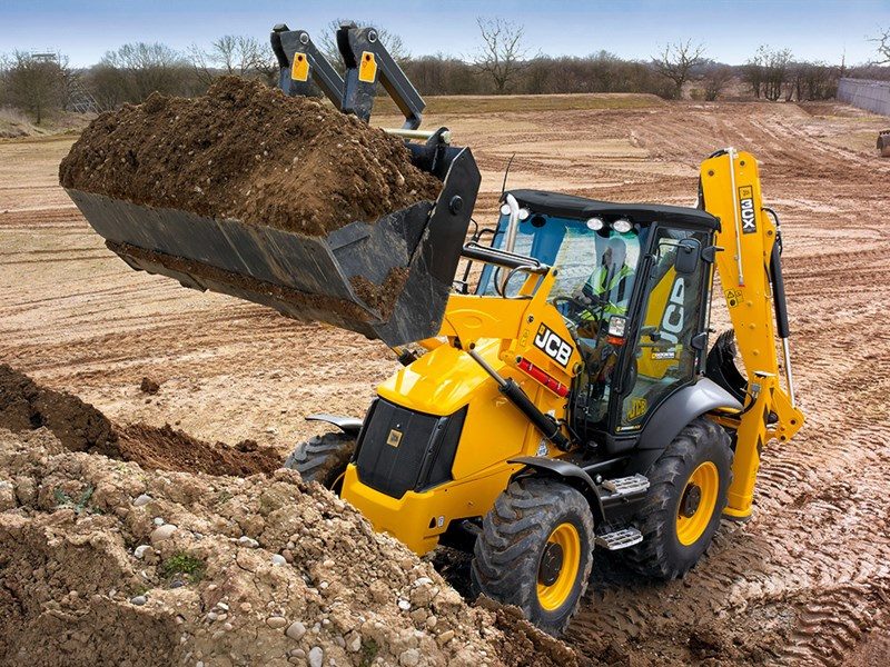 JCB 3CX lifting a full bucket of soil on an earthworks site