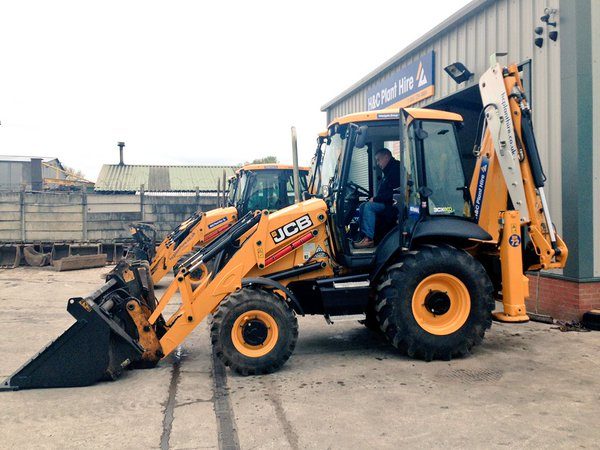 Side view of a JCB 3CX backhoe loader outside the H&C workshop
