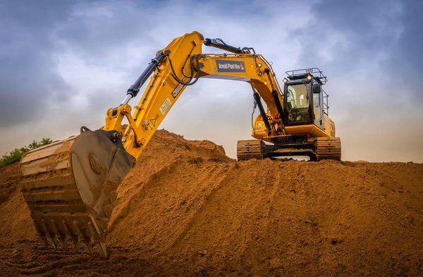 Tracked excavator digging into a bank of soil