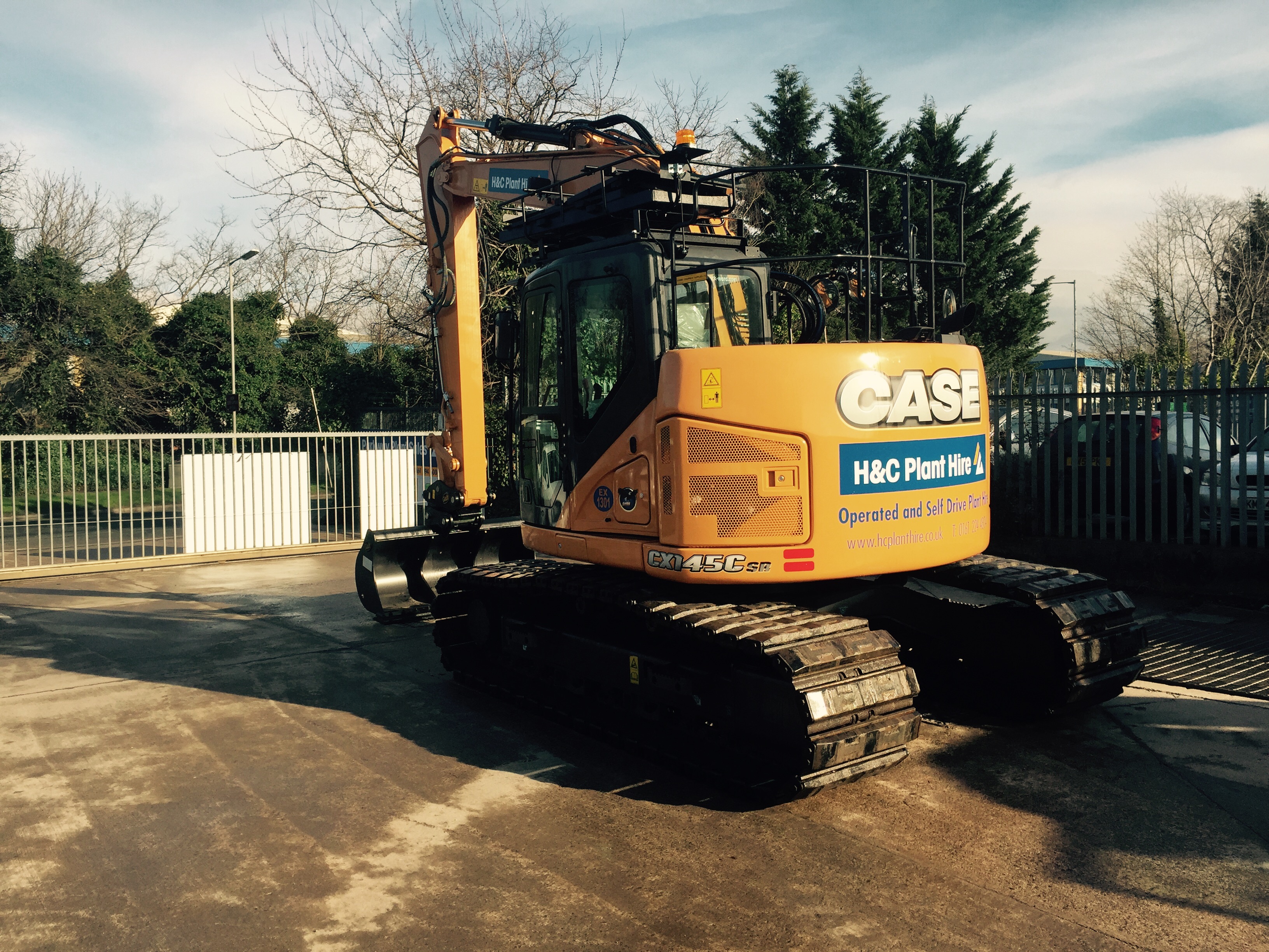 Rear view of a CASE tracked excavator with H&C Plant Hire signage