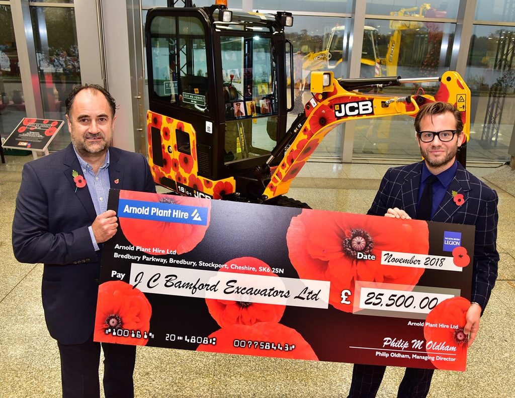 Charity cheque presentation in front of a poppy-liveried JCB mini excavator